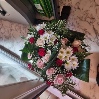 Bouquet de roses, chrysanthèmes et gypsophiles sur un fond marbré.