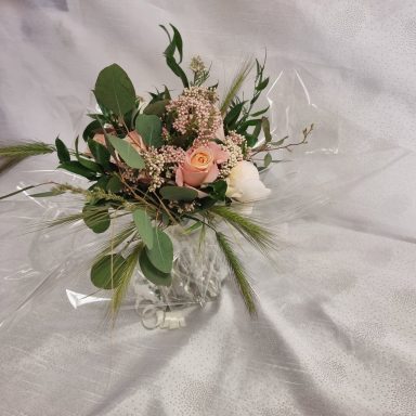 Bouquet de fleurs roses et blanches, entouré de feuillage vert.